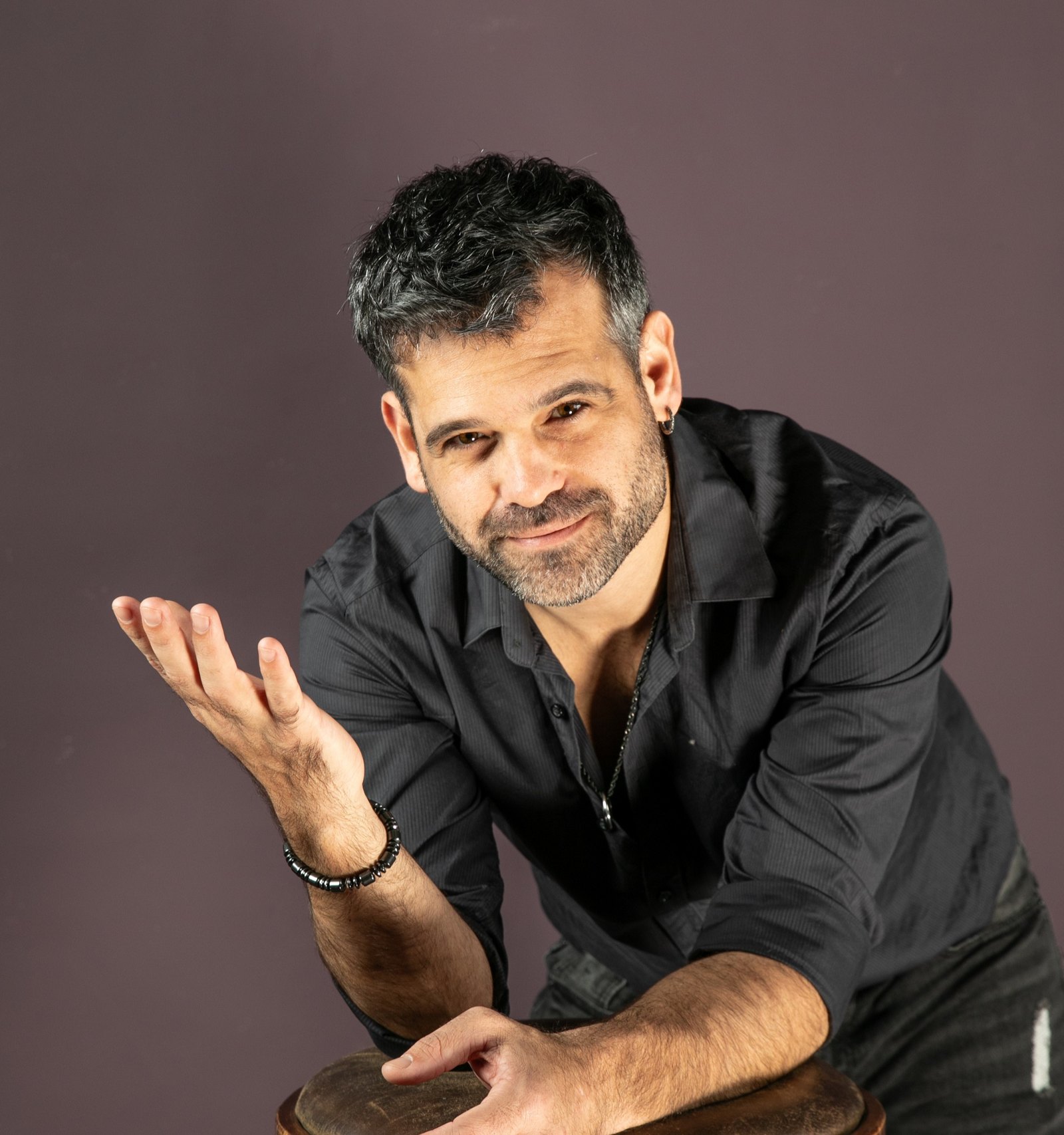 סשה בלבין במחווה פתוחה ומזמינה, חיוך חם